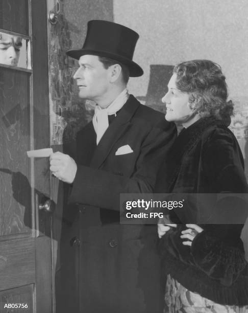 couple in formal wear showing pass to man at speakeasy door (b&w) - speakeasy stock pictures, royalty-free photos & images