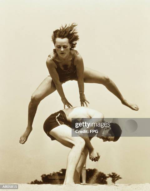 young couple playing leapfrog at beach (b&w sepia tone) - archive 2005 stock-fotos und bilder