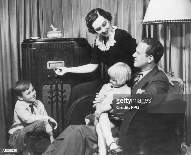 parents and children (4-10) listening to radio set (b&w) - 20s fotografías e imágenes de stock