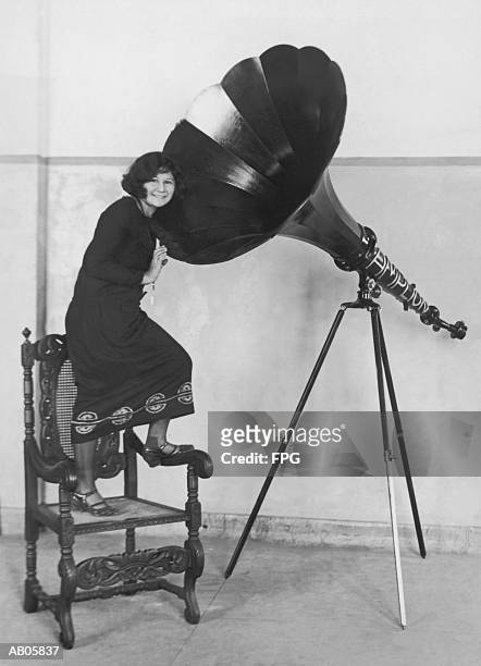 woman standing on chair by large mechanical amplifier (b&w) - roaring 20s stock pictures, royalty-free photos & images