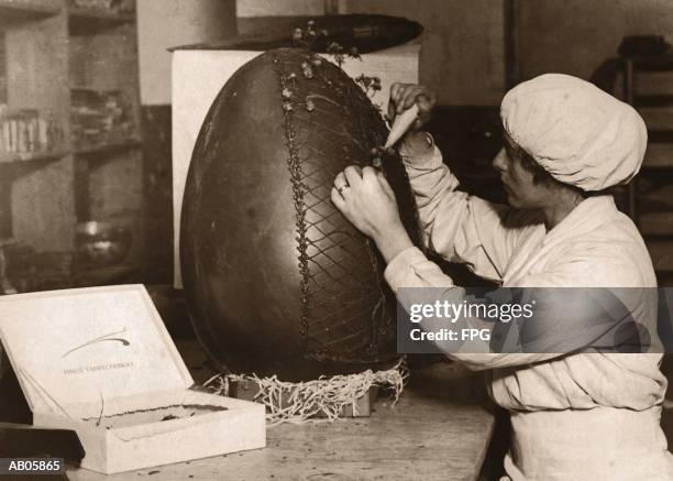 woman decorating fifteen pound chocolate easter egg (b&w sepia) - archive 2005 stock-fotos und bilder