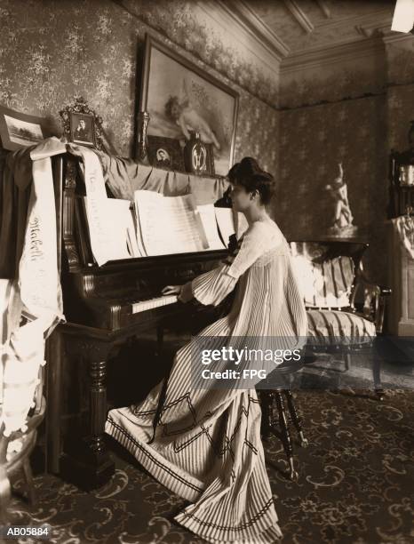 young woman playing piano in long dress, profile (b&w sepia tone) - pianist imagens e fotografias de stock