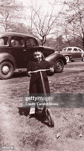 girl (6-8) on scooter, portrait (b&w) - 20th century stockfoto's en -beelden