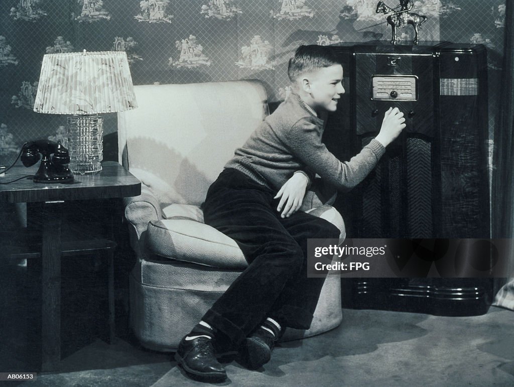 Teenage boy (13-15) tuning radio (B&W)