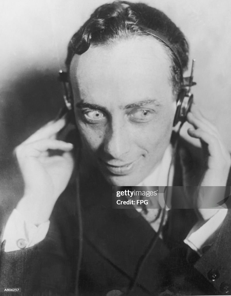 Man wearing headphones, smiling, close-up (B&W)