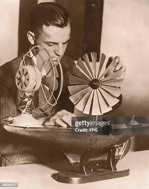 man testing model of windmill ship propeller (b&w sepia tone) - ship propeller stock pictures, royalty-free photos & images
