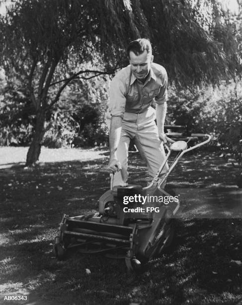 man starting lawn mower (b&w) - b 47 - fotografias e filmes do acervo