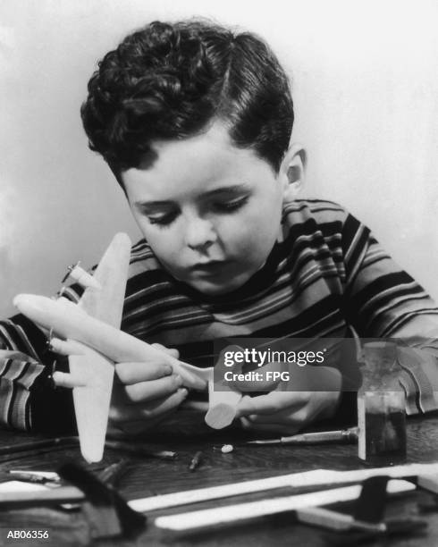 boy (7-9) building model airplane (b&w) - building model airplane stock pictures, royalty-free photos & images
