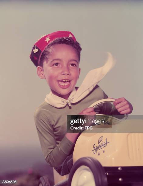 boy (5-7) sitting in toy car - soapbox cart foto e immagini stock