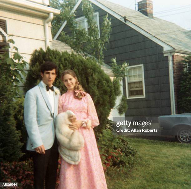 teenage couple (16-18) wearing formal attire on lawn, portrait - zondagse kleren stockfoto's en -beelden