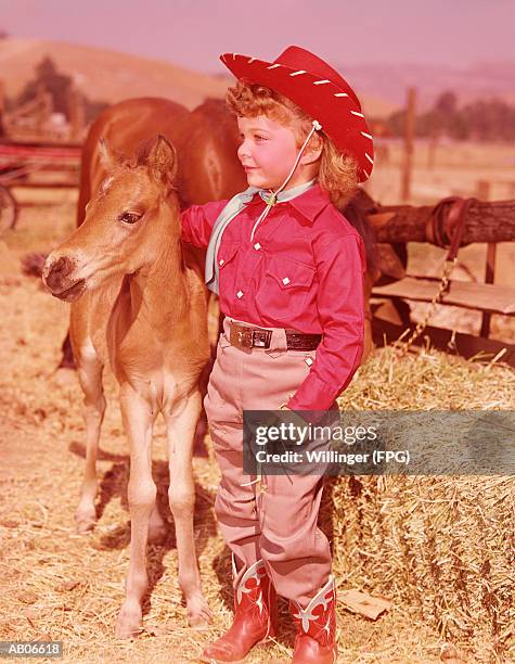 young cowgirl standing with her pony, portrait - girl and blond hair and cowboy hat stock pictures, royalty-free photos & images