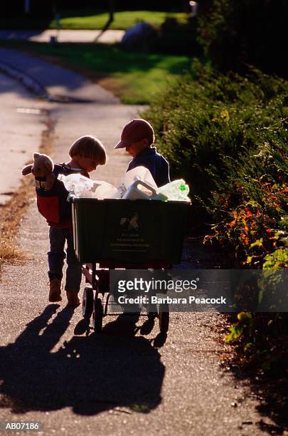 two boys (3-6) wheeling recycling bin - wheeling imagens e fotografias de stock