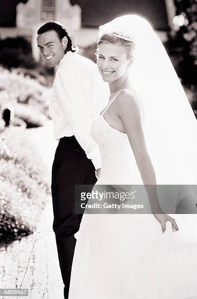 bride and groom walking together (b&w) - two toned dress stockfoto's en -beelden