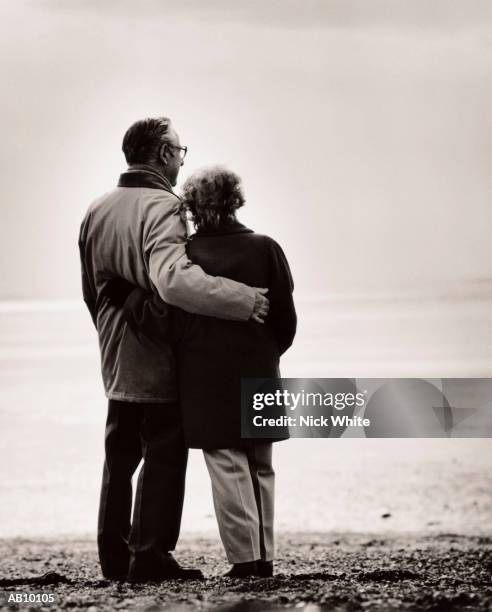 mature couple on the beach, on a chillyday - 2000 64 64 stock pictures, royalty-free photos & images