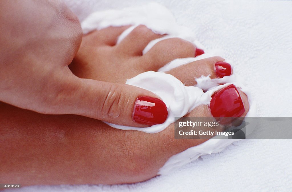 Woman applying cream to foot