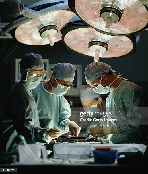 surgeons performing surgery - surgery stock pictures, royalty-free photos & images
