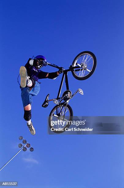 man on bicycle doing stunt, low angle view, mid-air - carl stockfoto's en -beelden