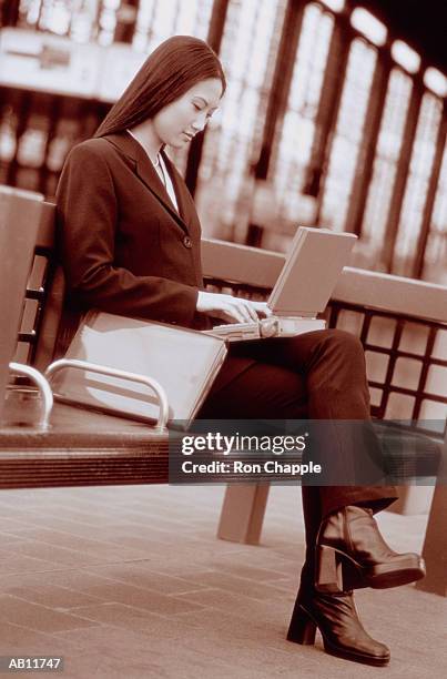 vietnamese businesswoman with laptop at train station (b&w) - transportation building type of building stock pictures, royalty-free photos & images