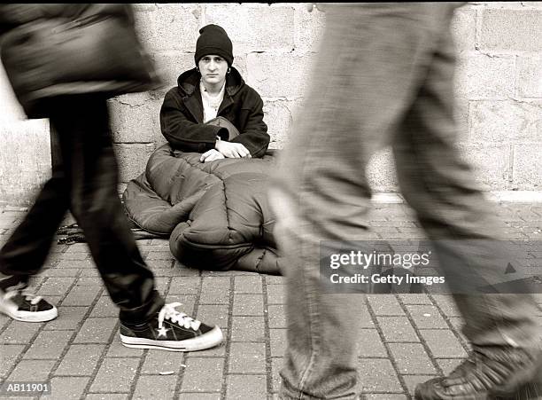 people walking by homless man, sitting on street, (b&w) - tiggande bildbanksfoton och bilder