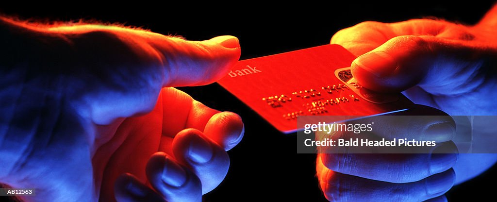 Man passing credit card to other man, close-up