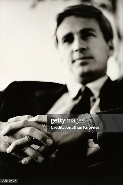 businessman relaxing in chair clasping hands, close-up (b&w) - b 47 - fotografias e filmes do acervo