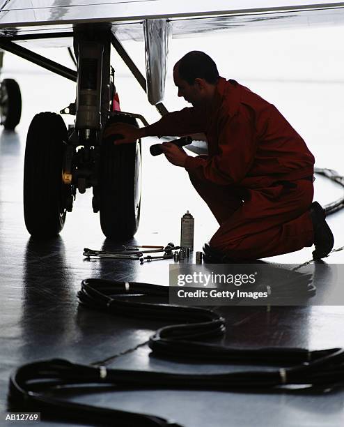 man working on landing gear on airplane - イングランド東部 ストックフォトと画像