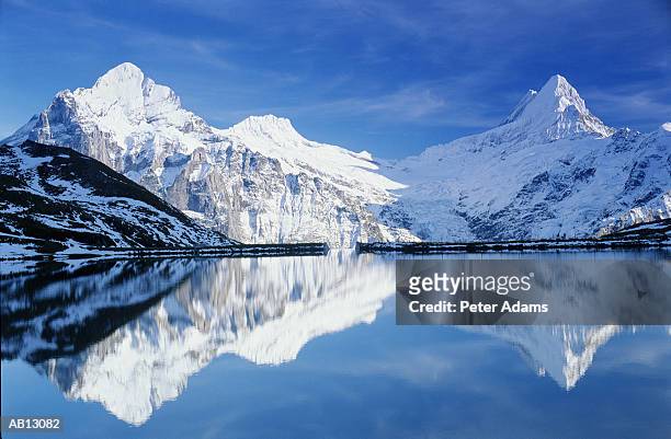 switzerland, swiss alps, mountains reflected in lake water - schweizer alpen stock-fotos und bilder