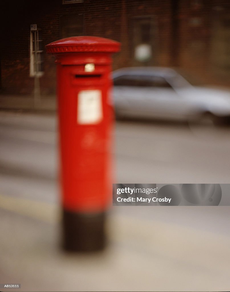 Red British postbox on urban street