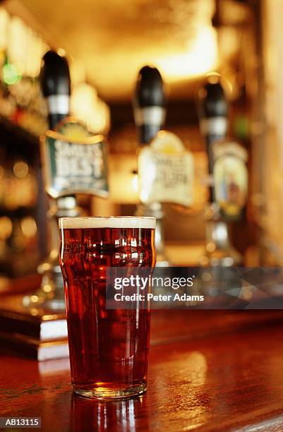 pint of beer on bar (selective focus) - cerveza-tipo-ale fotografías e imágenes de stock
