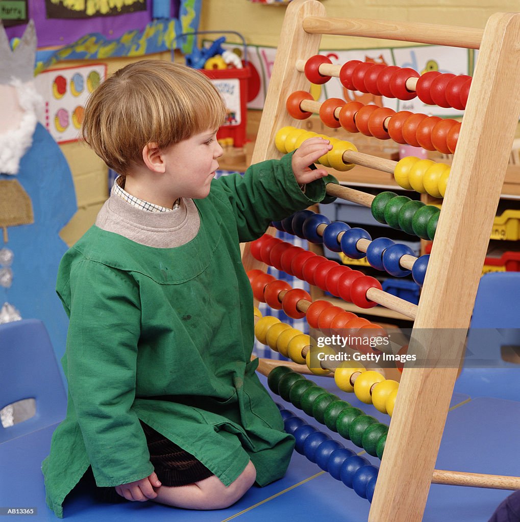 Boy (2-4) playing with abucus