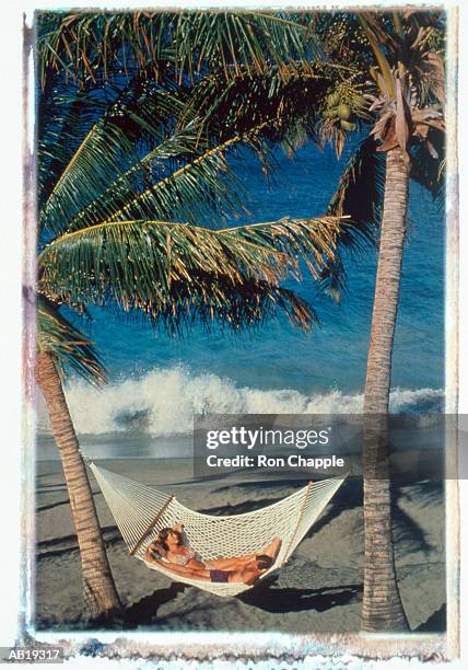 couple lying in hammock on beach - kona coast stock pictures, royalty-free photos & images