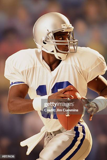 quarterback looking over shoulder, preparing to throw football - cummins stock pictures, royalty-free photos & images