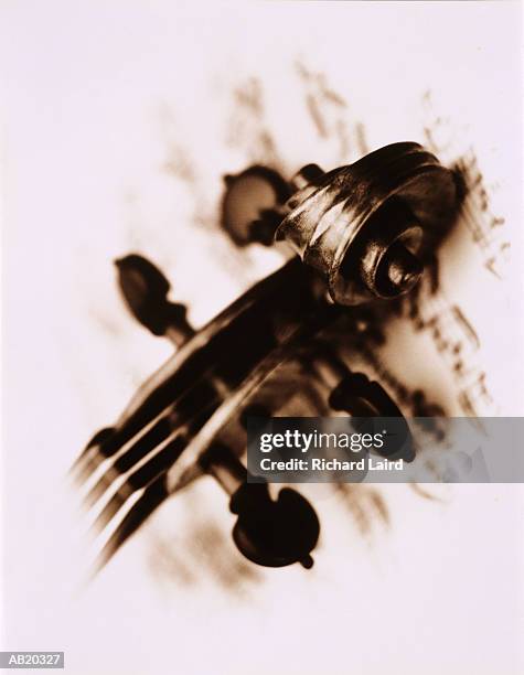 stradivarius violin scroll on sheet music (vignette, toned b&w) - violin scroll stock pictures, royalty-free photos & images