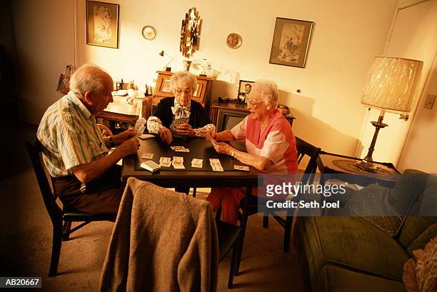 three elderly people playing cards - seth stock pictures, royalty-free photos & images