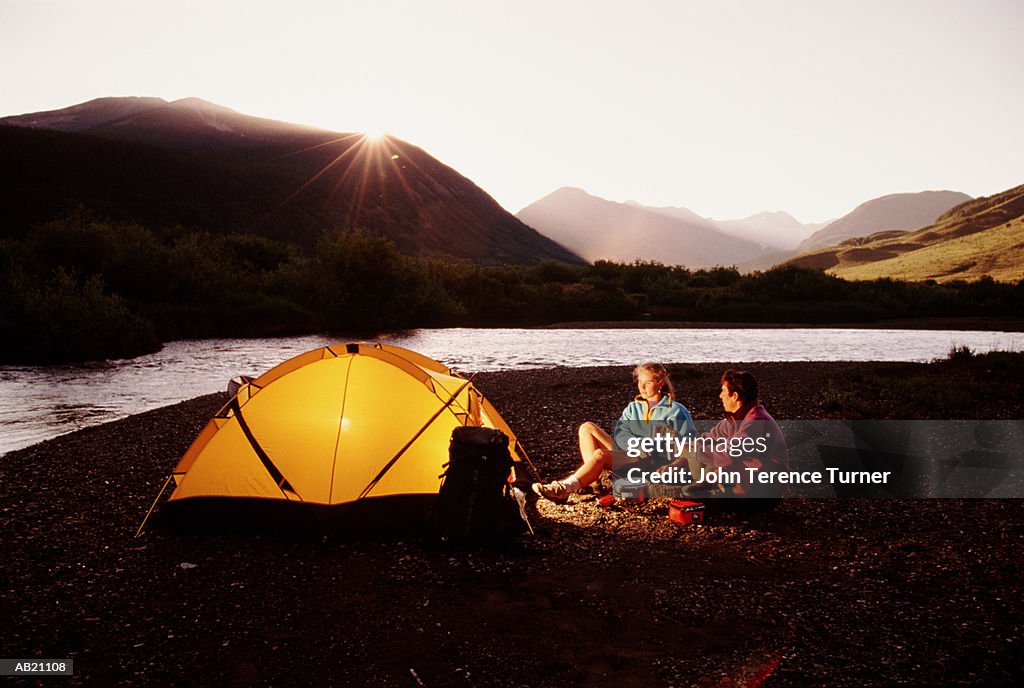 USA, Colorado, Crested Butte, couple camping by lake at sunset