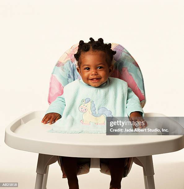 baby girl (6-9 months) in highchair, wearing bib - baby bib stock pictures, royalty-free photos & images