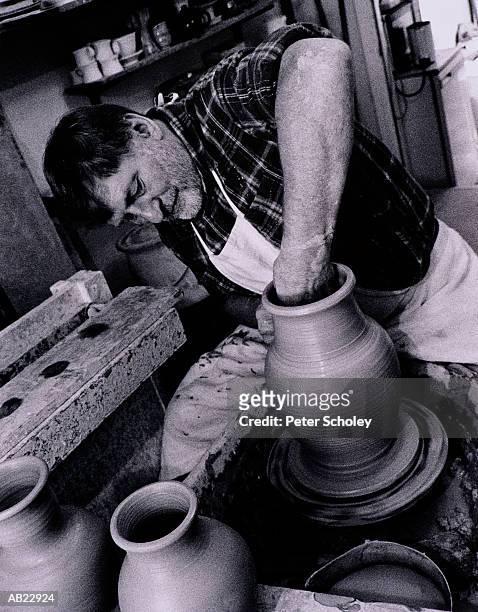 mature man working with clay on pottery wheel (b&w) - b 47 - fotografias e filmes do acervo