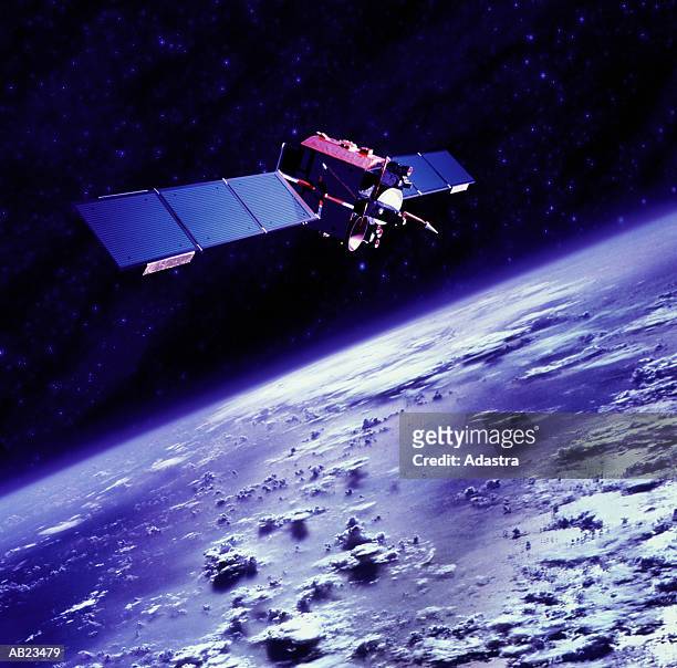 communications satellite orbiting above earth - satélites imagens e fotografias de stock