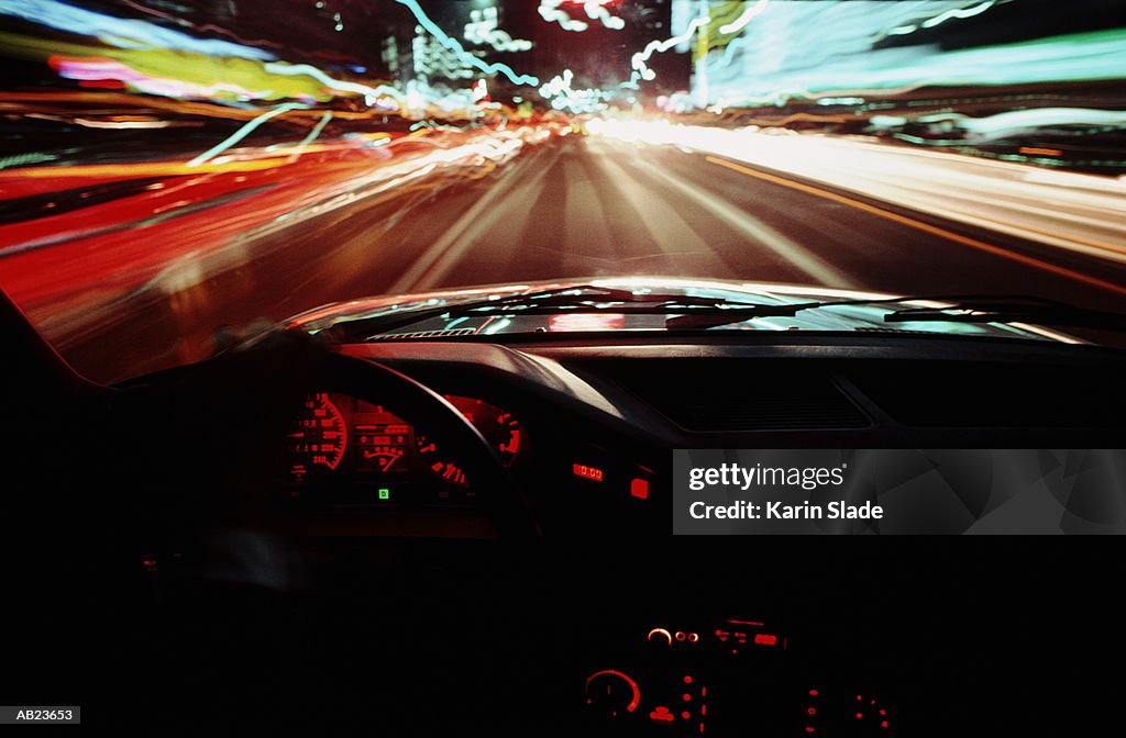 Traffic in street at night, view through windscreen (blurred motion)