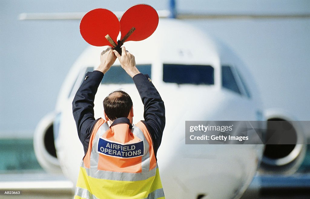 Airfield operator signaling to airplane