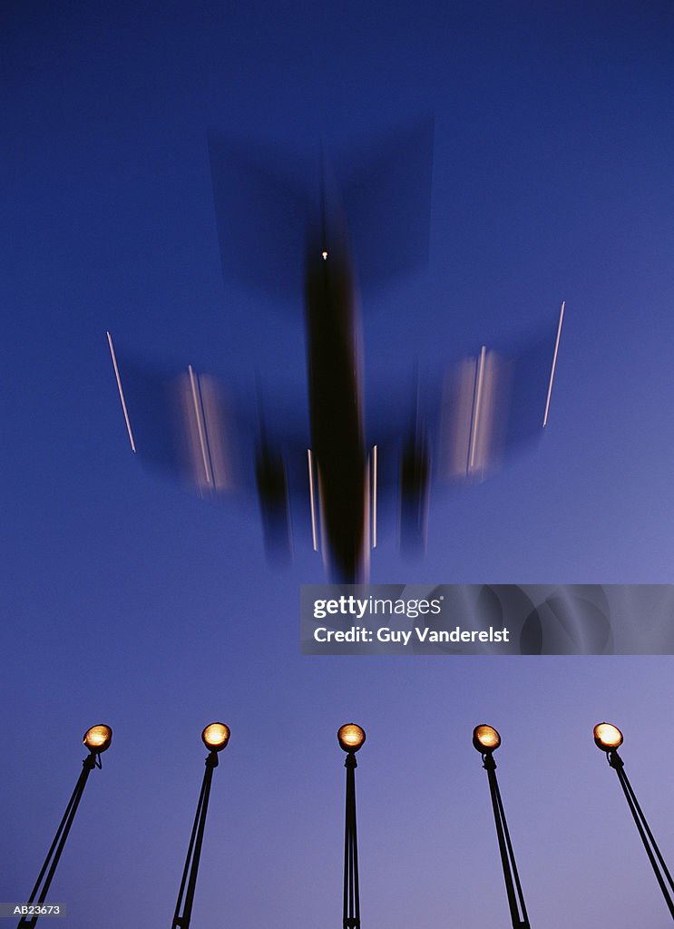 Airplane landing, dusk, low angle view (blurred motion)