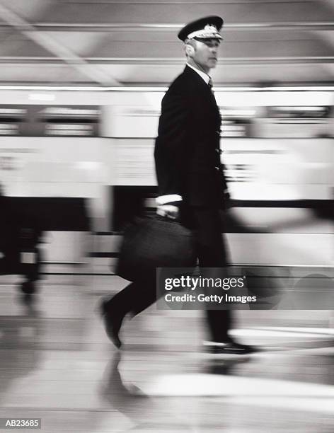 pilot walking through airport with suitcase, blurred motion, (b&w) - eastern england 個照片及圖片檔