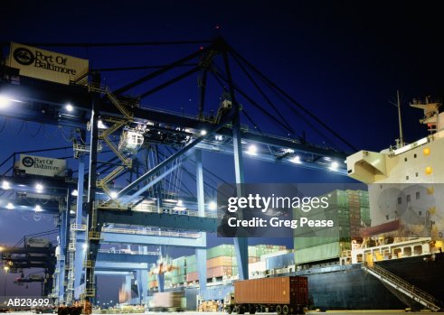 Hydraulic cargo crane loading freighter, night, low angle view Hydraulic cargo crane loading freighter, night, low angle view
