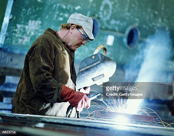 welder working at ship yard, sparks flying - sparks fotografías e imágenes de stock