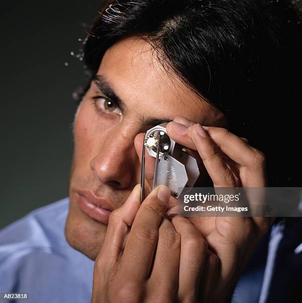 man viewing diamond through loupe, portrait - examining diamond stock pictures, royalty-free photos & images