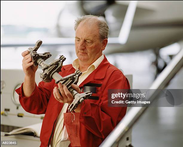 man inspecting torque shaft rudder in airplane hanger - getty images uk stock pictures, royalty-free photos & images