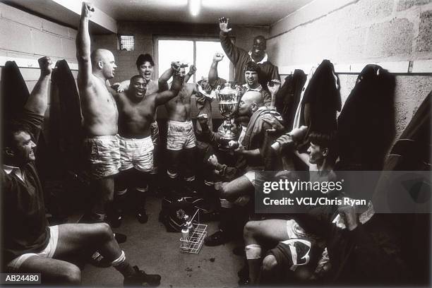 rugby team celebrating in locker room with trophy (b&w) - amateur rugby stock pictures, royalty-free photos & images