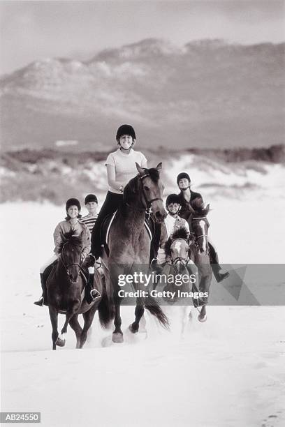 groupe of young horseback riders on beach, (b&w) - cavalgada de lazer imagens e fotografias de stock
