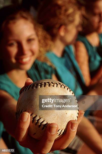 teenage girls' softball team sitting in dugout (focus on softball) - dugout stock pictures, royalty-free photos & images