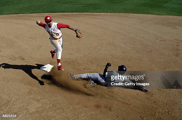 infielder making double play, runner sliding into second base - baseball helmet photos et images de collection